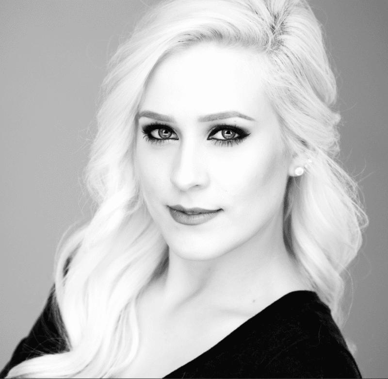 Bella Mallow, a young caucasian woman with long blonde hair and dark eye makeup, close-up headshot in high-contrast black & white.